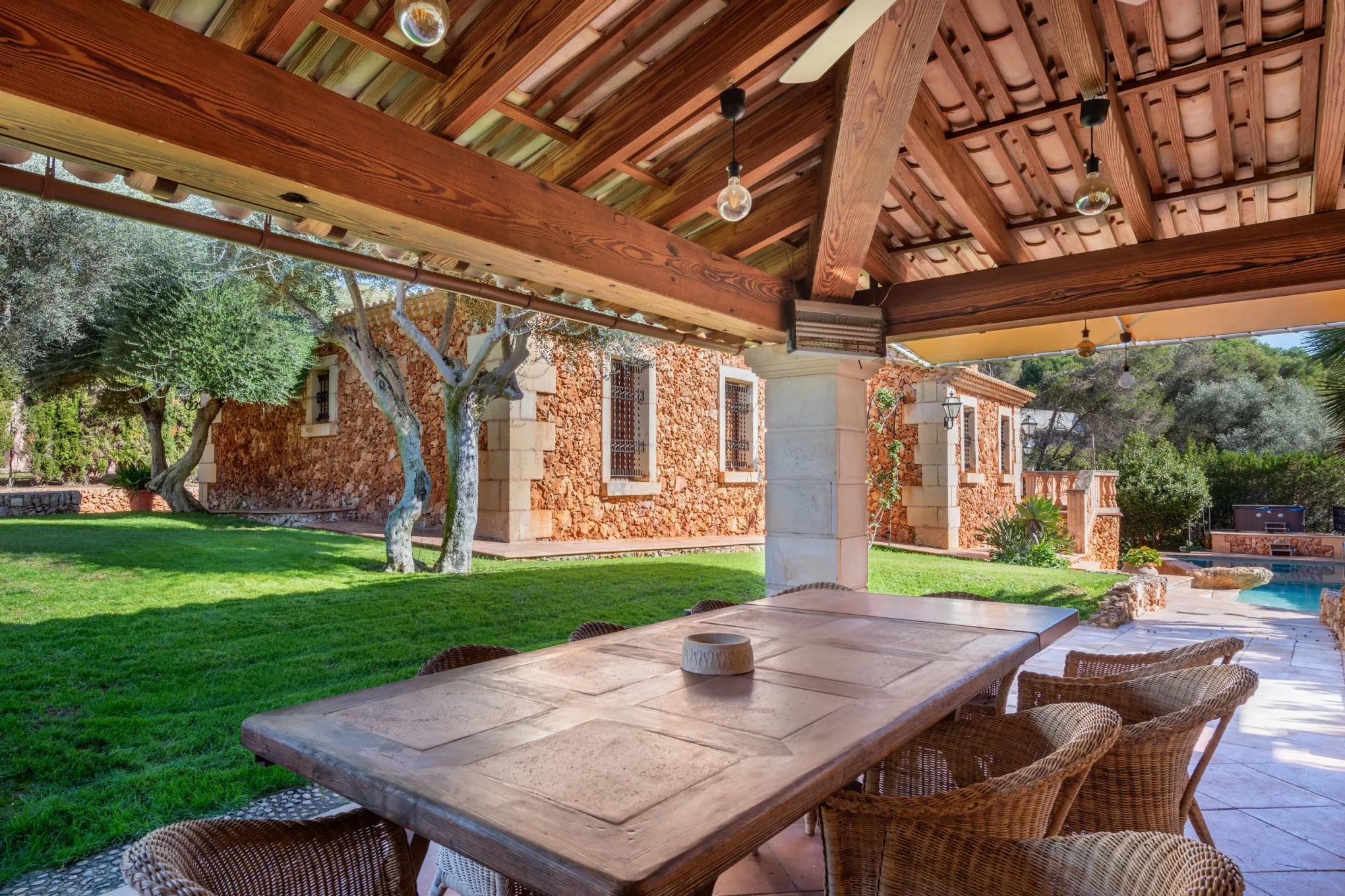 Dining terrace under timber beams among olive trees, Costa de los Pinos, Mallorca